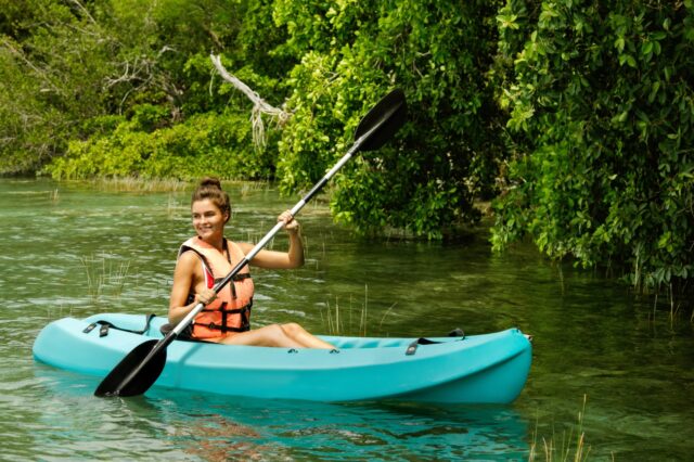 Young woman kayaking in mangrove